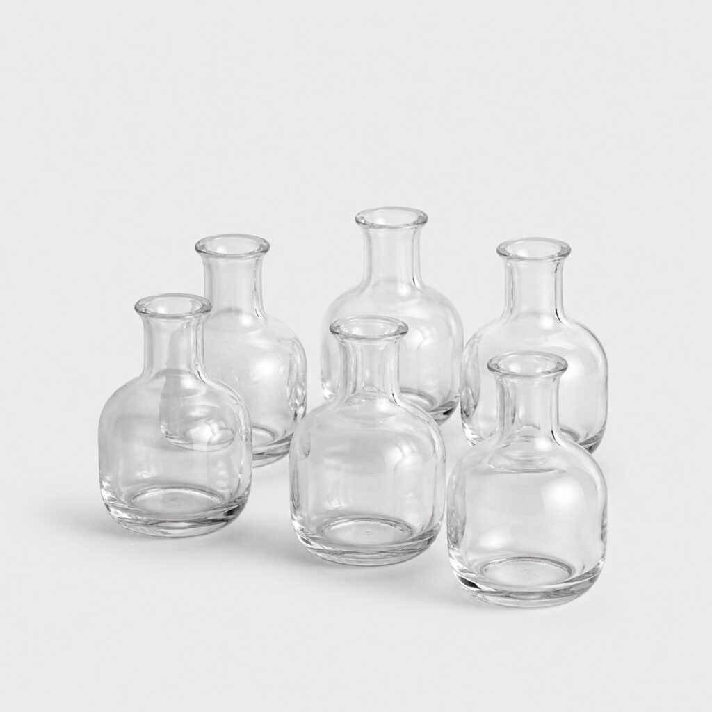 Lot de petits vases en verre transparent de type soliflore sur fond gris clair