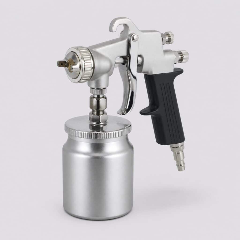 Pistolet à peinture pneumatique à godet inférieur sur fond gris clair