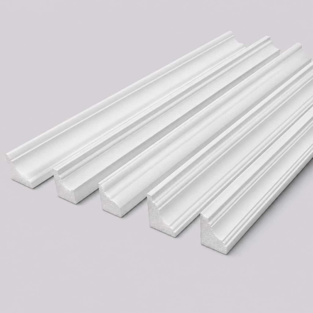 Lot de moulures de plafond blanches de profils différents sur fond gris clair